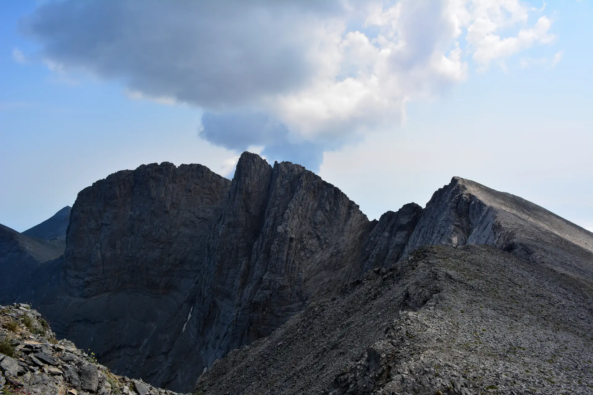 View from Skolio peak of Mount Olympus showing the steep west face of Mytikas and Stefani Throne of Zeus in Greece